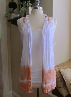 an orange and white scarf is hanging on a mannequin