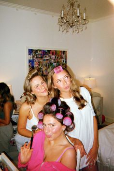 three girls are posing for the camera with their hair rollers in front of them