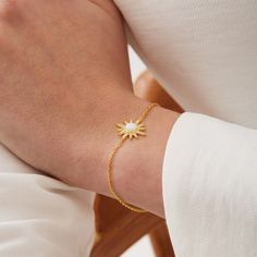 a person wearing a gold bracelet with a star on it