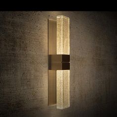 a wall light that is on the side of a building with concrete walls behind it