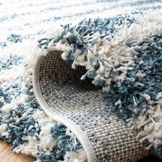 a blue and white rug on the floor with a wooden floor in front of it