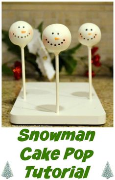 three snowman cake pops sitting on top of a white tray