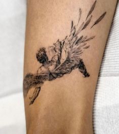 a woman's arm with a tattoo on it that has an image of a man falling from the sky