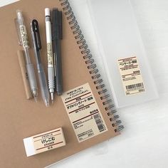 a notebook with some pens and other items on it