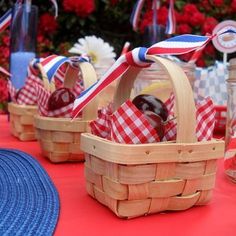 picnic table with red, white and blue baskets filled with food on top of it