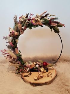 a floral wreath on top of a wooden slice