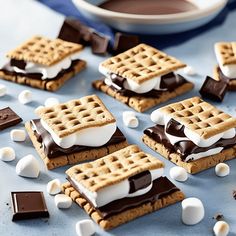 chocolate and marshmallow waffles are arranged on a blue table with white candy