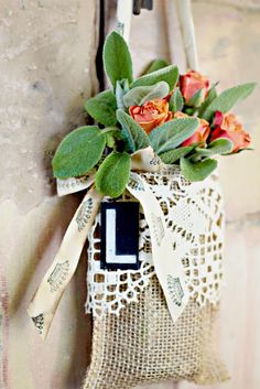 a burlap bag with flowers hanging from the side and a tag attached to it