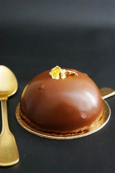 a chocolate cake on a plate next to a spoon