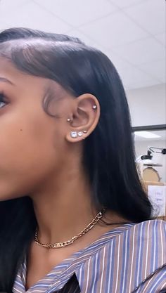 a close up of a person with ear piercings on their ears and wearing a striped shirt