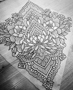 a black and white drawing on top of a piece of paper with an intricate design