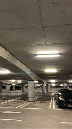 an empty parking garage with two cars parked in the lot and no one is there