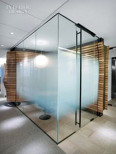 an office with glass walls and wooden slats