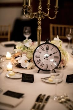 an image of a table setting with flowers and candles on it for a wedding reception