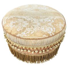 a round ottoman with tassels on it