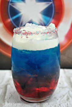 an american flag drink in a glass with sprinkles on the rim and red white and blue liquid