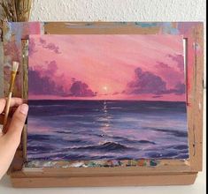 someone is painting a sunset over the ocean