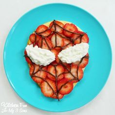 a blue plate topped with strawberries and whipped cream