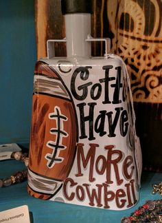 a cowbell shaped bottle sitting on top of a table next to beads and necklaces