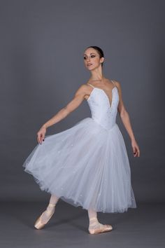 a woman in a white dress and ballet shoes