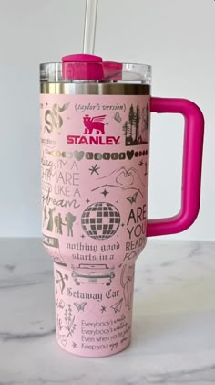 a pink travel mug with the words stanley on it and a straw sticking out of it