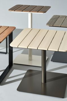 three wooden tables and one metal table with wood slats on the sides, all in different colors