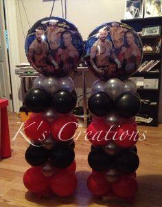 two balloons are stacked on top of each other in front of a table with pictures