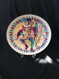 a decorative plate with an image of a man playing the guitar on it's side