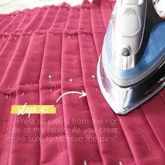 an iron is sitting on top of a red cloth with the words step 11 press all pieces from the right side of the fabric as you press, make sure to remove the pins