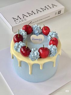 the cake is decorated with cherries and blue flowers