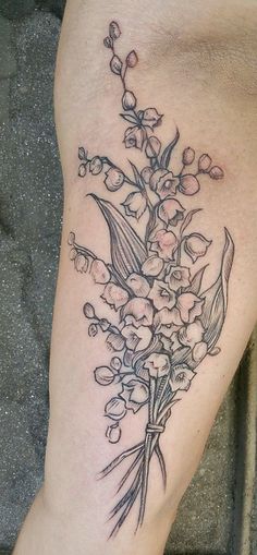 a tattoo on the leg of a woman with flowers and leaves growing out of it