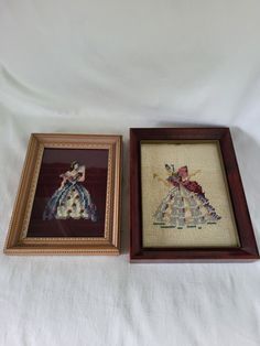 two framed cross - stitch pictures, one with a dress and the other with a hat