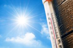 a thermometer is shown in front of a bright blue sky