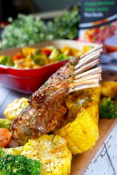 a wooden cutting board topped with meat and veggies