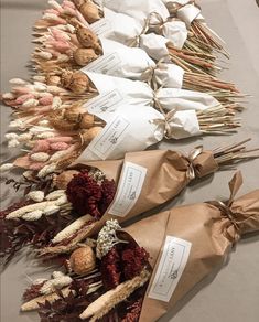 dried flowers are laid out on a table with paper wrapped in brown and white ribbons