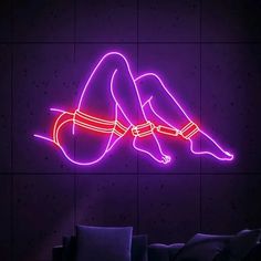 a neon sign with a woman laying on her stomach