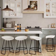 an image of a kitchen setting with bar stools and white countertops on the island