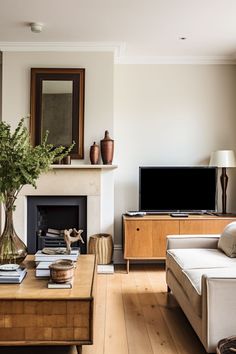 a living room filled with furniture and a flat screen tv on top of a wooden table