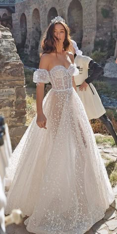 a woman in a wedding dress standing next to a motorcycle