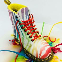 a pair of colorful painted shoes sitting on top of a white table covered in multicolored paint