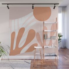 a living room with a large wall mural on the wall next to a chair and book shelf