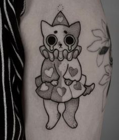 a woman with a tattoo on her arm that has a cat and hearts on it