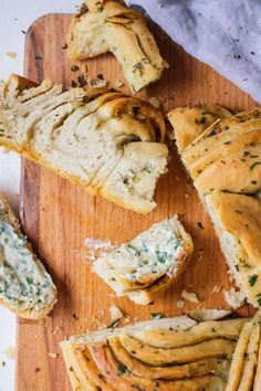 sliced bread with herbs and cheeses on a cutting board next to some garlic bread