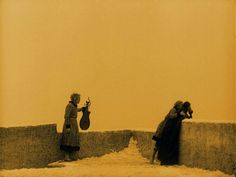 an old photo of two people standing next to each other on the side of a wall