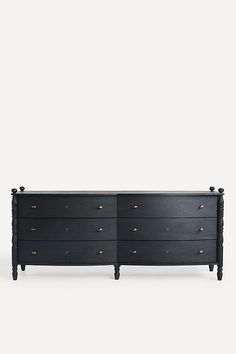 a black dresser with gold knobs on the top and bottom, against a white background