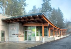 an empty building on the side of a road with trees in the backgroud