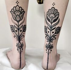 a woman's legs with black and white floral tattoos on her leg, both showing the