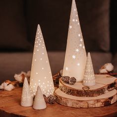 three white christmas trees on a wooden table