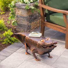 a toy dinosaur sitting on top of a stone floor next to a chair and table