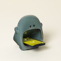 a cell phone is in a little elephant shaped holder that holds it's mouth open